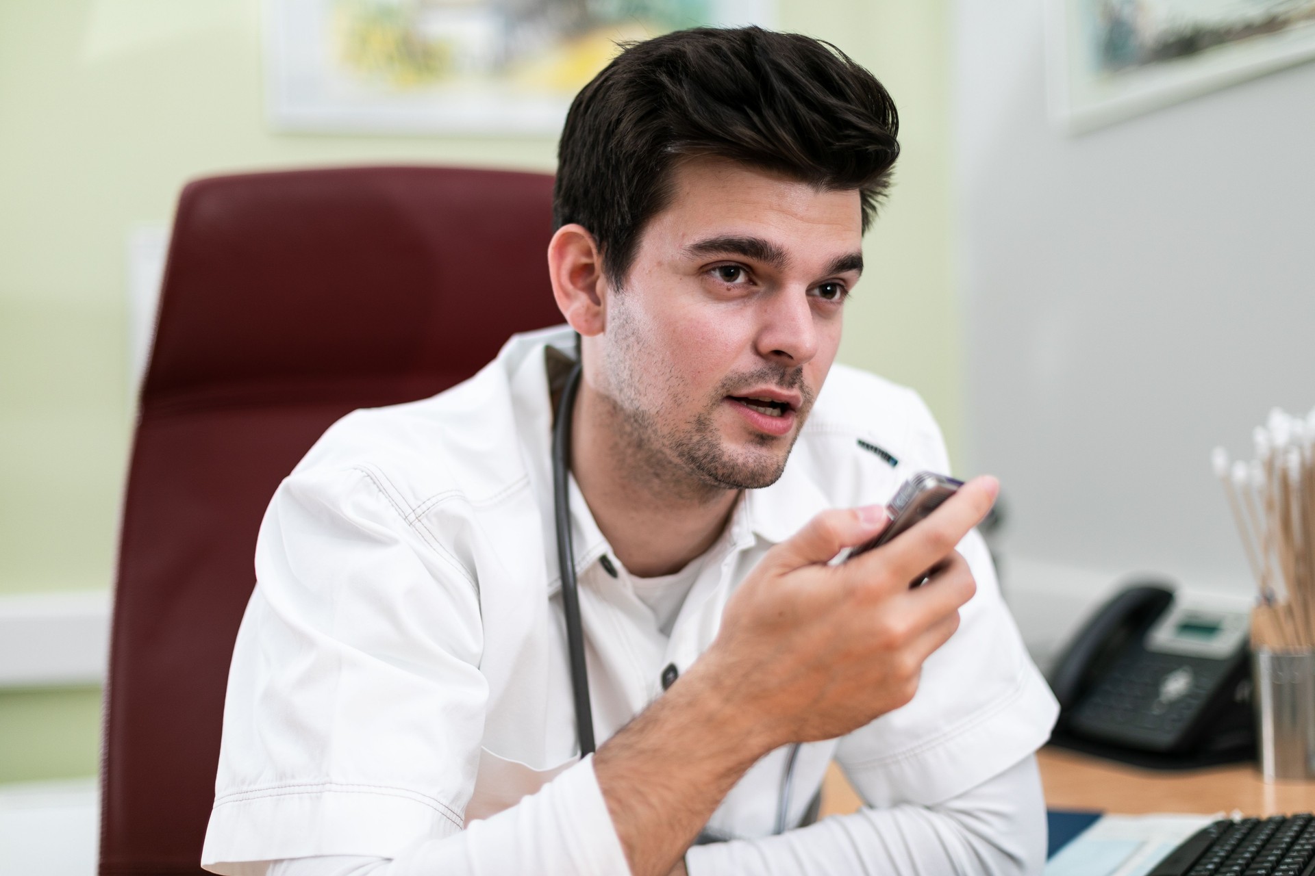 Young doctor talking into Dictaphone  - type recorder